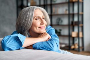 A mature woman smiling with confidence from restored teeth.