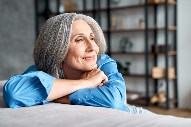 A mature woman smiling with confidence from restored teeth.