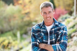 Male dental implants patient stands confident after receiving implants in Addison, TX.