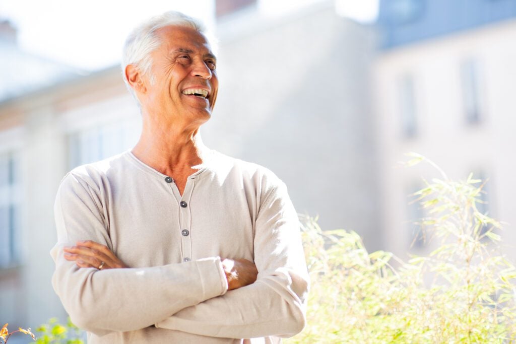 A mature man smiling after dental restoration in Addison.