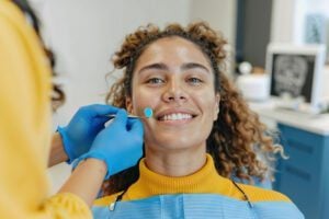 A young woman smiling at her stress-free dental appointment in Addison.