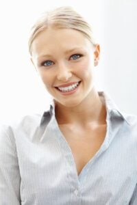 A young woman smiling after professional teeth whitening in Addison.