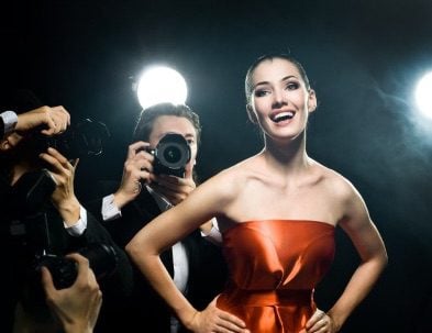 A young woman smiling in front of cameras after cosmetic dentistry in Addison.